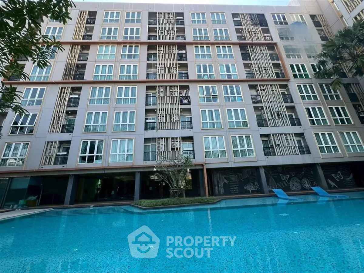 Modern apartment building with poolside view and stylish facade design.