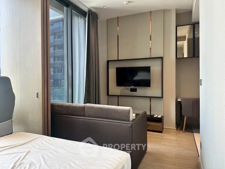 Modern studio apartment with sleek design and large windows offering city views.