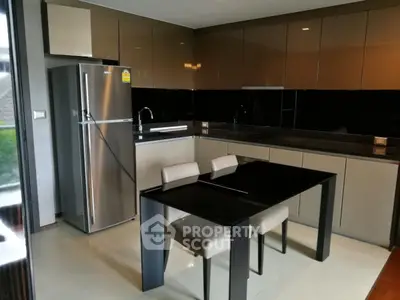Modern kitchen with sleek cabinetry and stainless steel fridge in a stylish apartment.