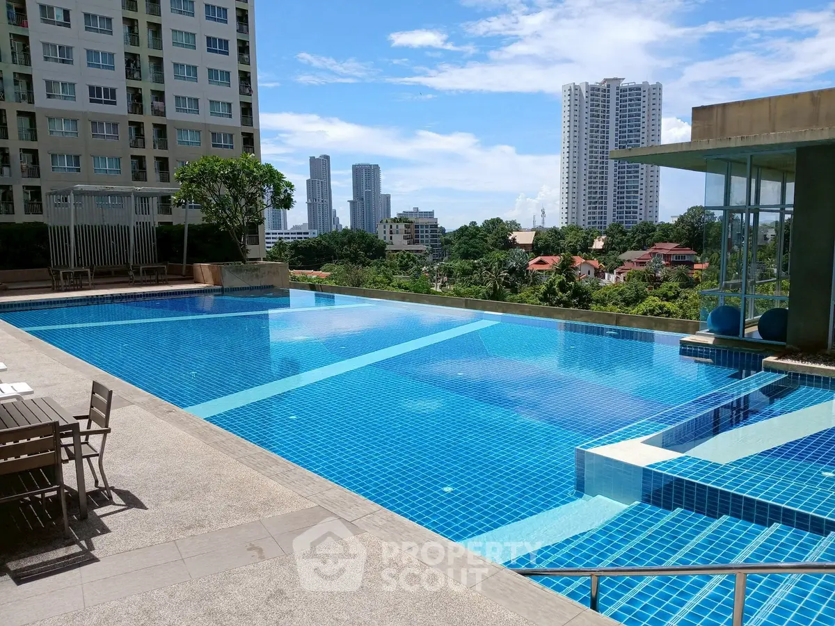 Luxurious rooftop pool with stunning city skyline views in modern apartment complex.