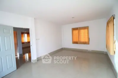 Spacious empty room with large windows and neutral tones, perfect for customization.