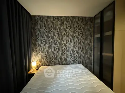 Modern bedroom with geometric wallpaper and cozy lighting