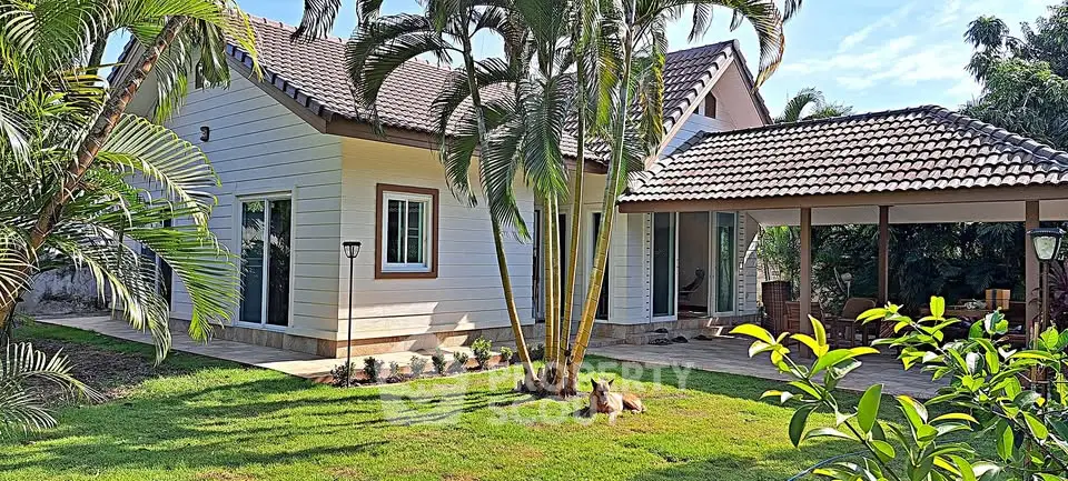 Charming tropical home with lush garden and spacious patio, perfect for outdoor relaxation.