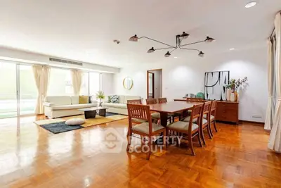 Spacious living and dining area with elegant wooden flooring and modern decor.