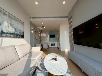 Modern living room with open kitchen, stylish decor, and natural light