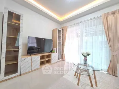 Modern living room with elegant decor, large TV, and natural light through sheer curtains.