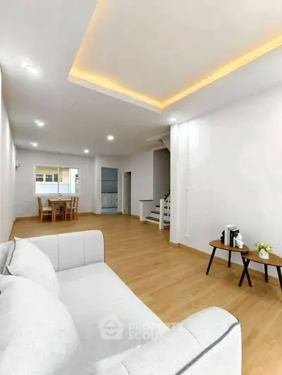 Spacious modern living room with elegant lighting and cozy seating area.