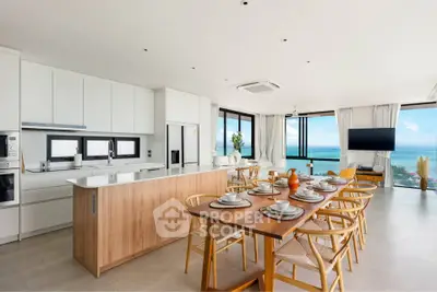 Luxurious open-plan kitchen and dining area with stunning ocean views, modern appliances, and elegant decor.