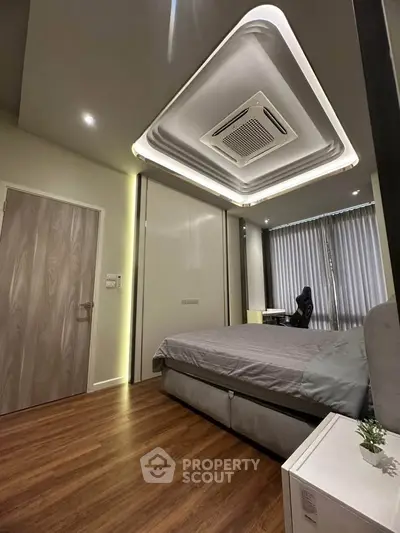 Modern bedroom with sleek design, featuring a cozy bed, stylish ceiling, and wooden flooring for a luxurious feel.
