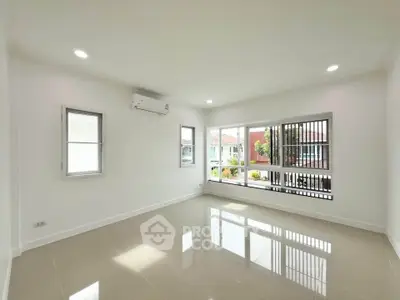 Spacious empty room with large windows and glossy tiled floor, perfect for customization.