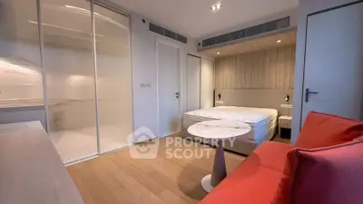 Modern bedroom with cozy seating and sleek design in a stylish apartment.