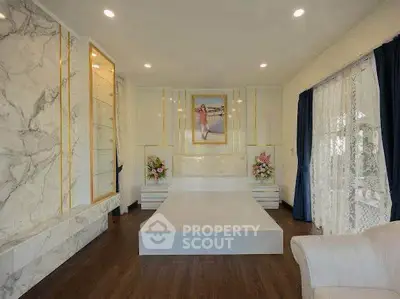 Luxurious bedroom with elegant marble accents and large windows for natural light.