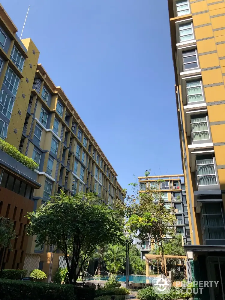 Modern apartment buildings with lush greenery and clear blue sky