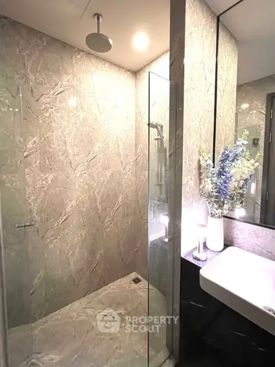 Luxurious marble bathroom with glass shower and elegant floral decor