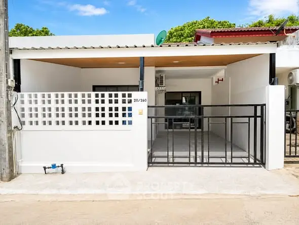 Charming single-story home with modern facade and gated entrance, perfect for cozy living.
