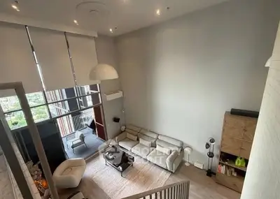 Spacious modern living room with high ceiling and large windows offering stunning views.
