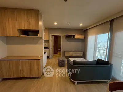 Modern living room with stylish furniture and large windows offering natural light and city views.