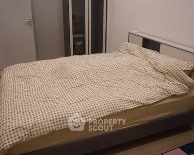 Cozy bedroom with modern bed and checkered bedding in a stylish apartment.