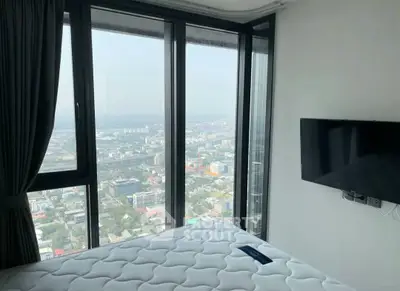 Modern bedroom with panoramic city view and wall-mounted TV