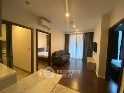 Modern apartment interior with open layout, featuring a cozy living room and adjacent bedroom.