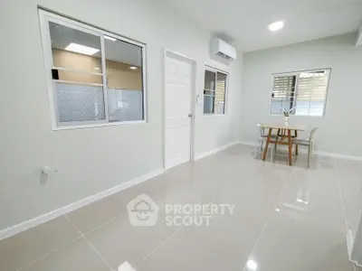 Spacious modern living area with sleek tile flooring and natural light