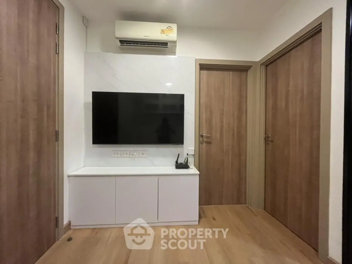 Modern living room with wall-mounted TV and air conditioning unit