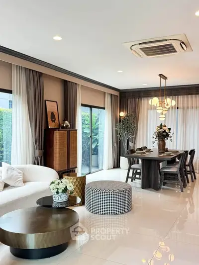 Luxurious open-plan living and dining area with elegant decor and large windows.