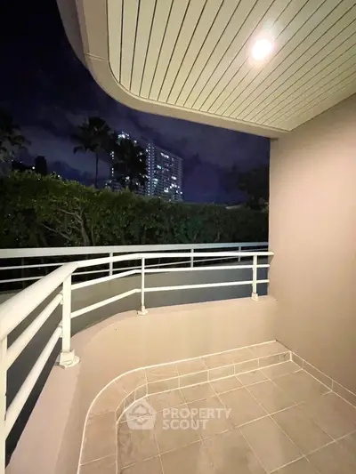 Spacious balcony with night city view, perfect for relaxation and entertainment.