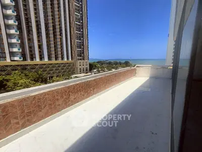 Spacious balcony with stunning ocean view in modern high-rise building.