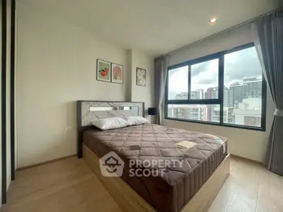 Modern bedroom with large window and city view, featuring stylish decor and cozy ambiance.