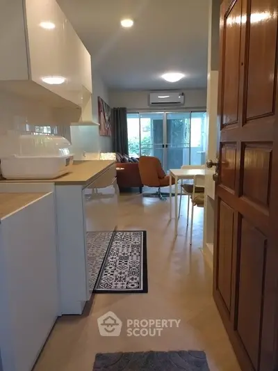 Charming open-layout living room with modern kitchen and cozy seating area, perfect for relaxation and entertaining.