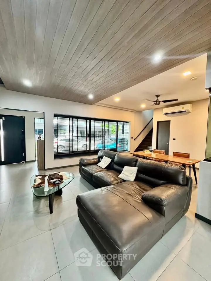 Spacious modern living room with leather sofa and large windows