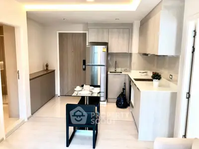 Modern open-layout kitchen with sleek cabinetry and stainless steel appliances in a stylish apartment.