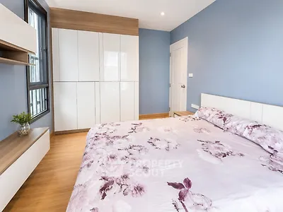 Spacious bedroom with floral bedding and modern storage solutions.