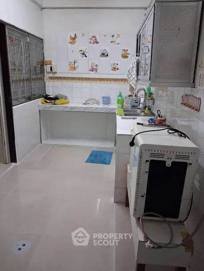Spacious kitchen with tiled walls and modern appliances, perfect for culinary enthusiasts.