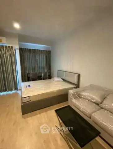 Modern bedroom with cozy bed and stylish sofa in a well-lit apartment
