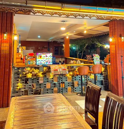 Charming outdoor dining area with warm lighting and cozy seating, perfect for evening gatherings.