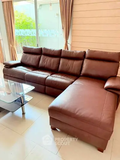Spacious living room with elegant leather sectional sofa and glass coffee table