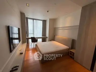 Spacious modern bedroom with large window and stylish furnishings
