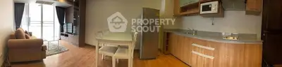 Spacious open-plan living room and kitchen with modern appliances and cozy seating area.