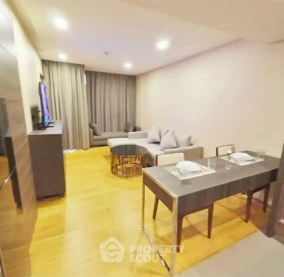 Modern living room with dining area, stylish furniture, and warm lighting in a cozy apartment.