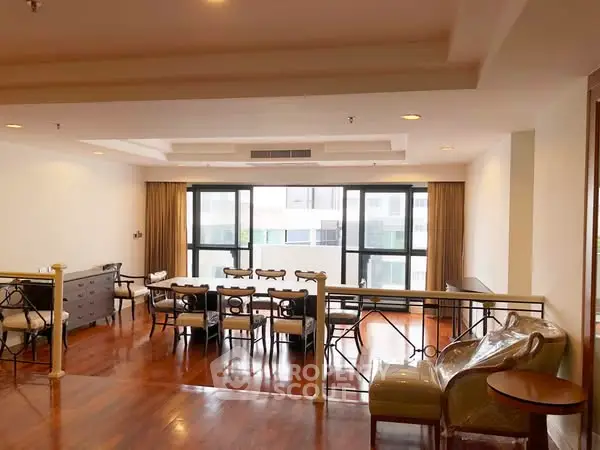 Spacious living room with elegant wooden flooring and large windows.