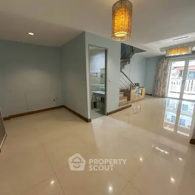 Spacious modern living room with elegant lighting and balcony access