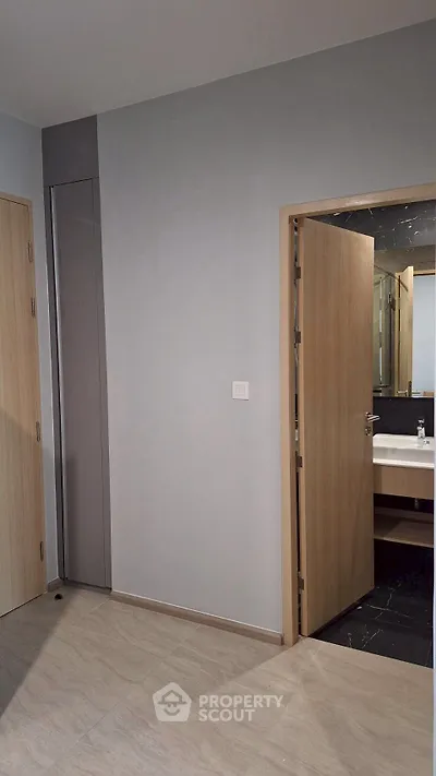 Modern bathroom entrance with sleek wooden door and minimalist design.