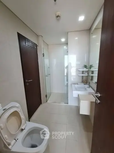 Modern bathroom with sleek fixtures and glass shower enclosure.