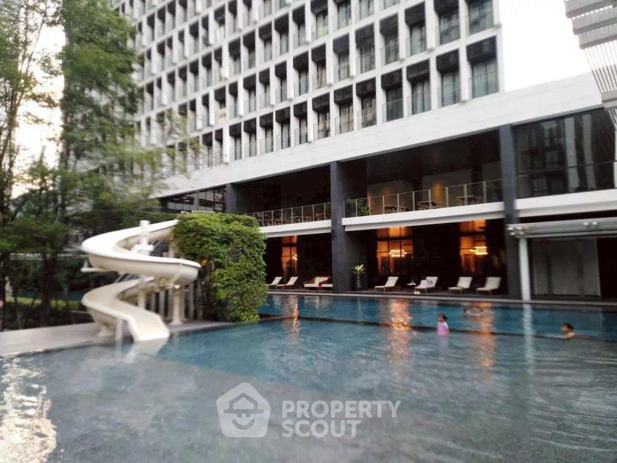 Luxurious apartment complex with stunning pool and slide, perfect for relaxation and leisure.