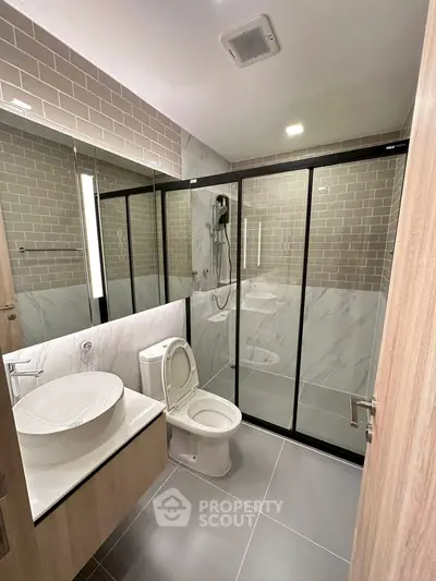 Modern bathroom with sleek design, glass shower, and stylish fixtures.