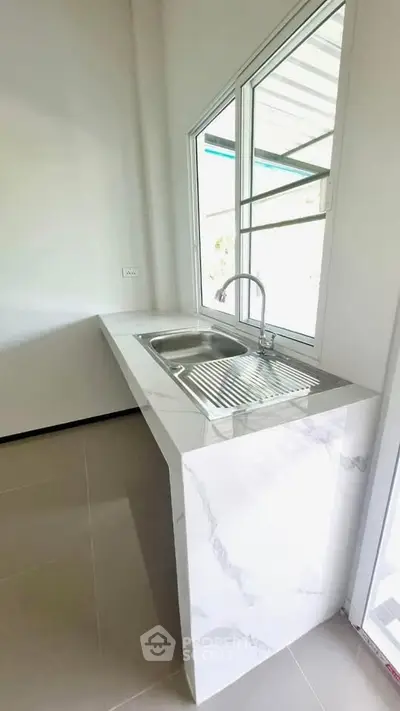 Modern kitchen with sleek marble countertop and stainless steel sink