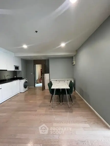 Modern open-plan kitchen and dining area with sleek design and hardwood floors.
