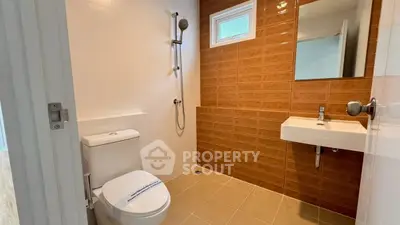 Modern bathroom with sleek fixtures and warm brown tiles